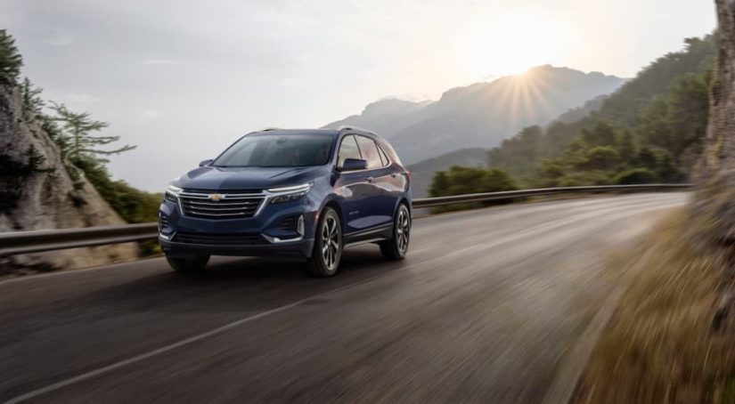 A blue 2022 Chevy Equinox is shown from the front at an angle on a mountain road.