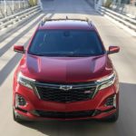 A red 2022 Chevy Equinox is shown from the front driving on an open road during a 2022 Chevy Equinox vs 2022 Honda CR-V comparison.