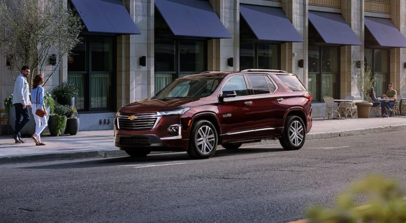 A maroon 2022 Chevy Traverse High Country is shown parked on the side of a city street.