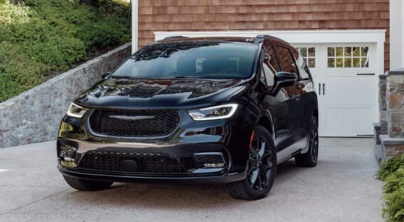 A black 2022 Chrysler Pacifica is shown from the front parked in a driveway.