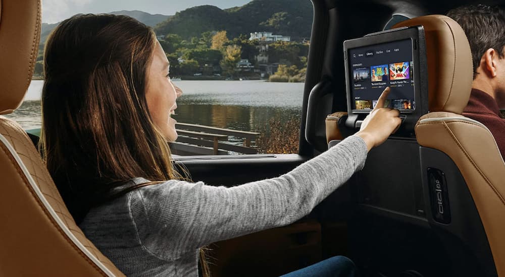 A child is shown using an infotainment screen in a 2022 Chrysler Pacifica.