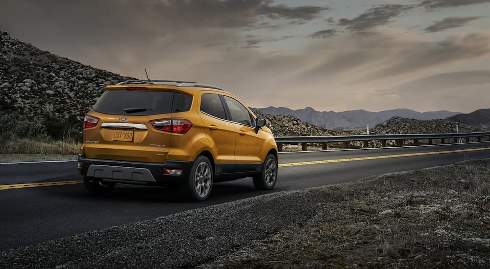 A yellow 2022 Ford EcoSport Titanium is shown driving on a mountain road.