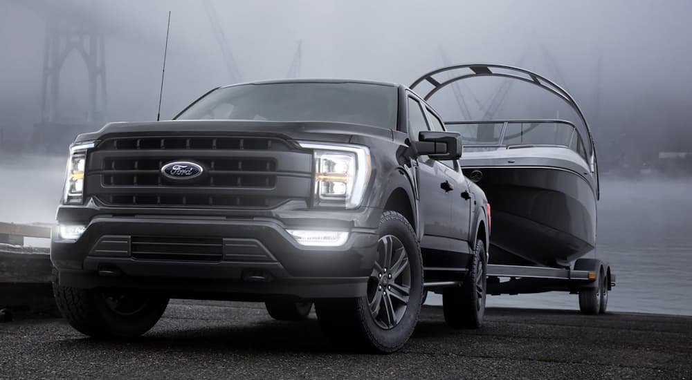 A black 2022 Ford F-150 is shown towing a boat.