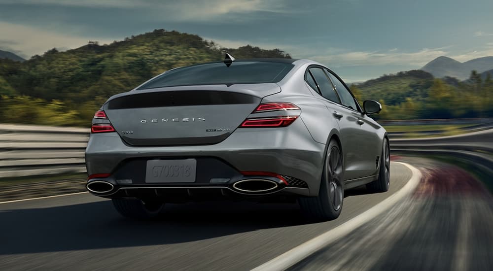A grey 2022 Genesis G70 AWD is shown from the rear driving on a highway.