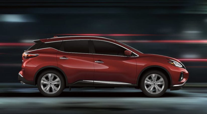 A red 2022 Nissan Murano is shown from the side driving through a tunnel during a 2022 Nissan Murano vs 2022 Chevy Blazer comparison.