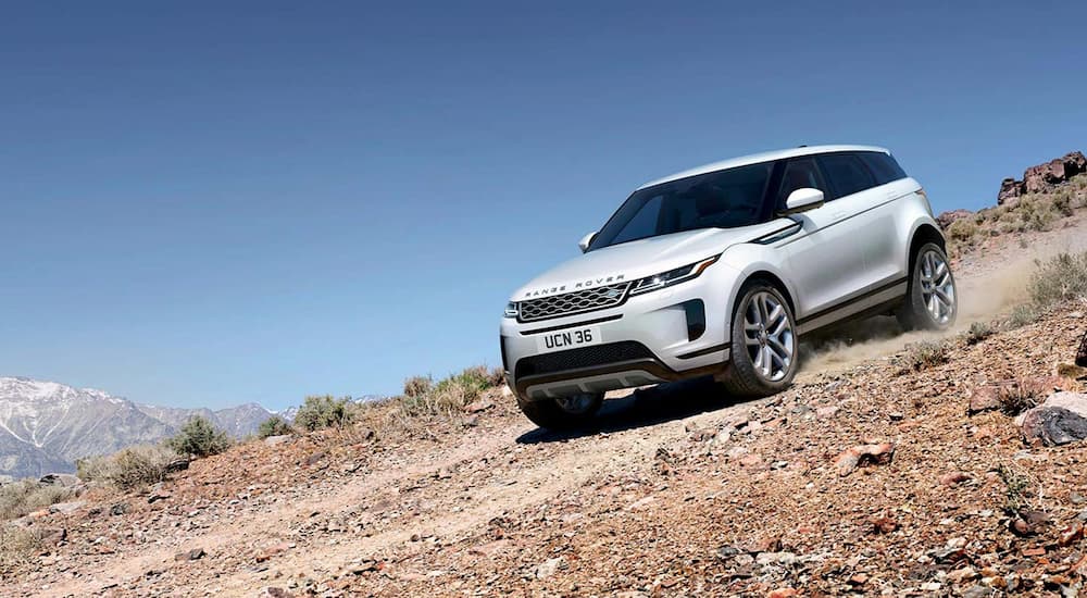 A white 2022 Range Rover Evoque SE is shown drivng on a dirt road.