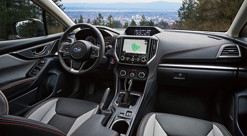 The black and grey interior of a 2022 Subaru Crosstrek Limited shows the steering wheel and center console.