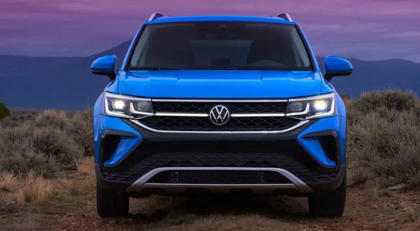 A blue 2022 Volkswagen Taos is shown from the front during a 2022 Volkswagen Taos vs 2022 Kia Seltos comparison.
