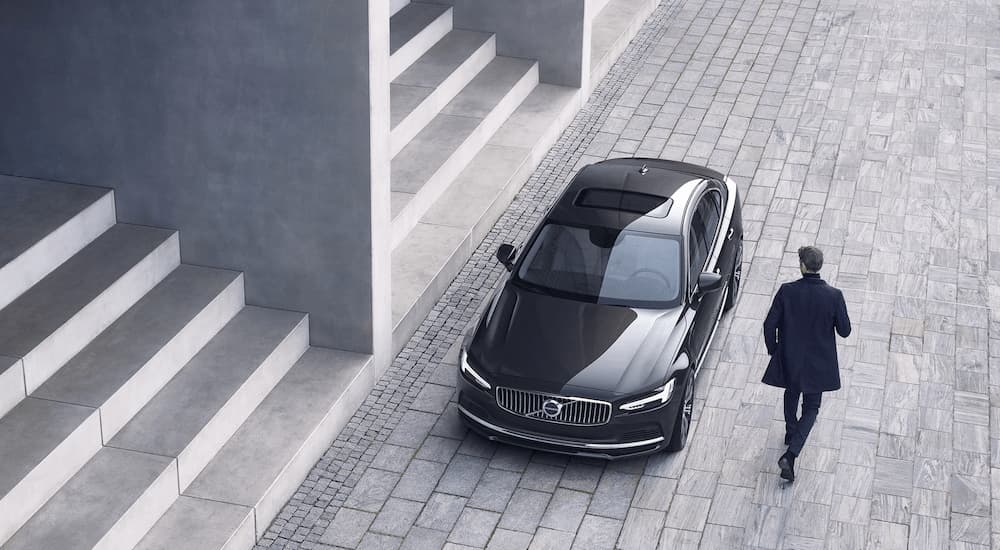 A black 2022 Volvo S90 is shown parked near a row of stairs.