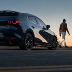 One of the more common used cars for sale, a black 2022 Mazda3 Turbo is shown from the rear at sunset.