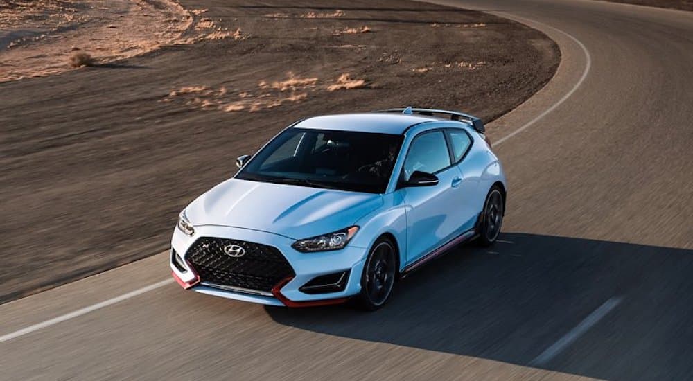 A white 2022 Hyundai Veloster N is shown from the front while rounding a corner.