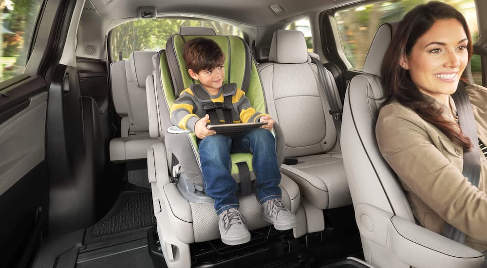 A child playing with a tablet is shown in a 2023 Honda Odyssey.