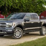 A grey 2022 Ford F-150 Limited is shown from the front at an angle on a dirt road during a 2022 Ford F-150 vs 2022 Ram 1500 comparison.