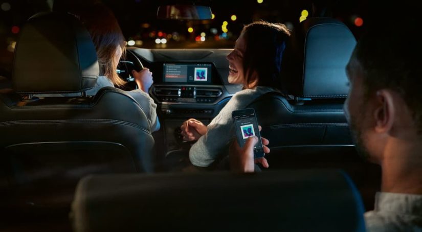 Friends are shown hanging out in a 2022 BMW 3 Series listening to music.