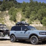 A grey 2022 Ford Bronco Sport is shown from the front at an angle while towing a UTV during a 2022 Ford Bronco Sport vs 2022 Honda HR-V comparison.