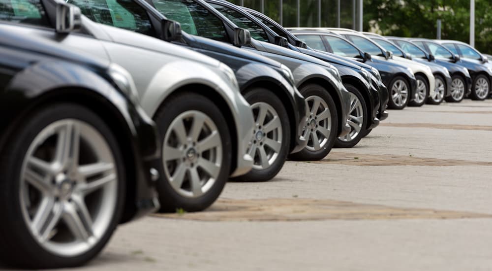 A line of cars is shown from the side at a car dealership.