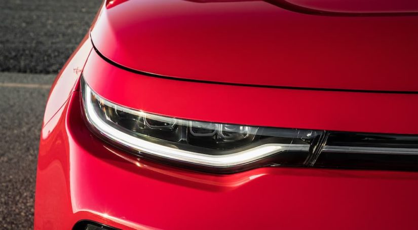 A close up shows the passenger headlight on a red 2020 Kia Soul after visiting a used Kia dealership.