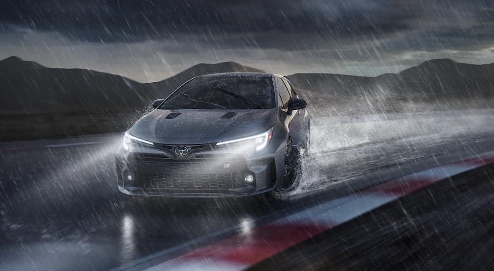 A grey 2023 Toyota GR Corolla is shown from the front while drifting in the rain after leaving an Illinois GR Corolla dealer.