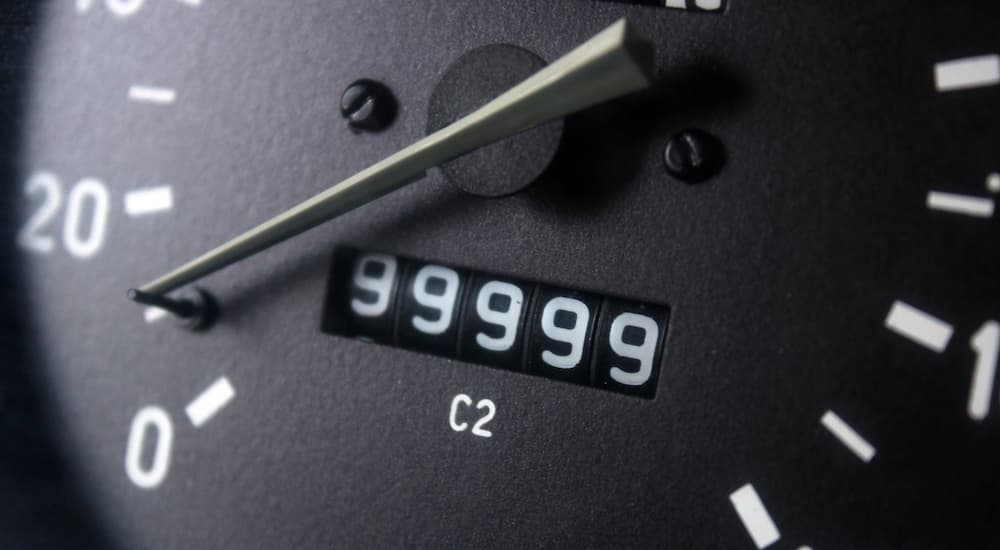 An odometer is shown close-up while reaching the 100,000 mile mark.