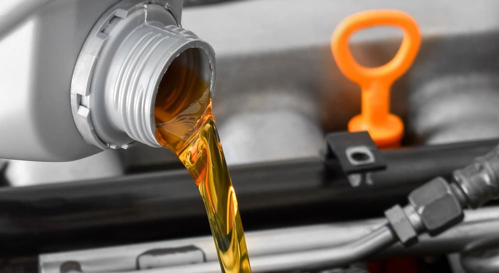 A close up of oil being poured into an engine is shown during an 'oil change near you.'