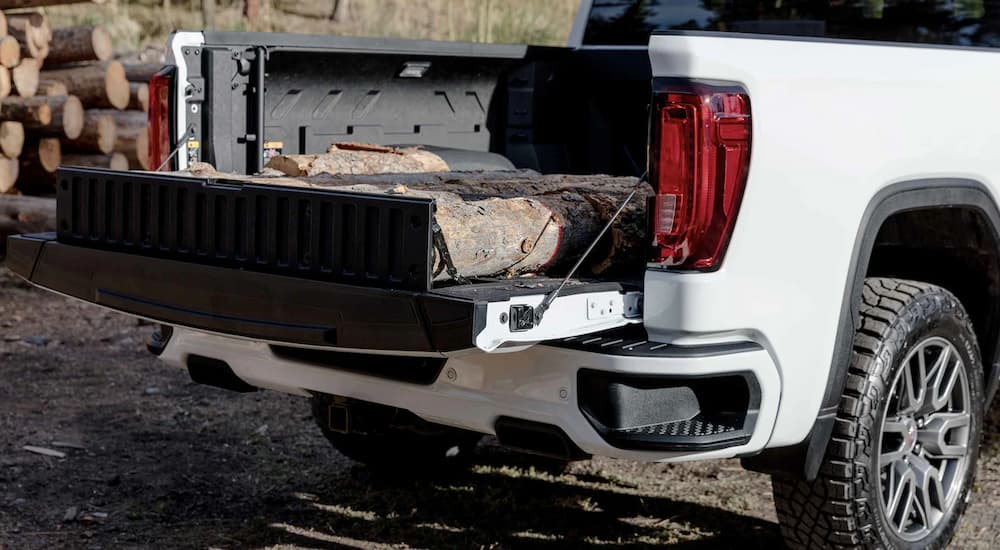 A white 2022 GMC Sierra 1500 AT4 is shown with the MultiPro Tailgate open.