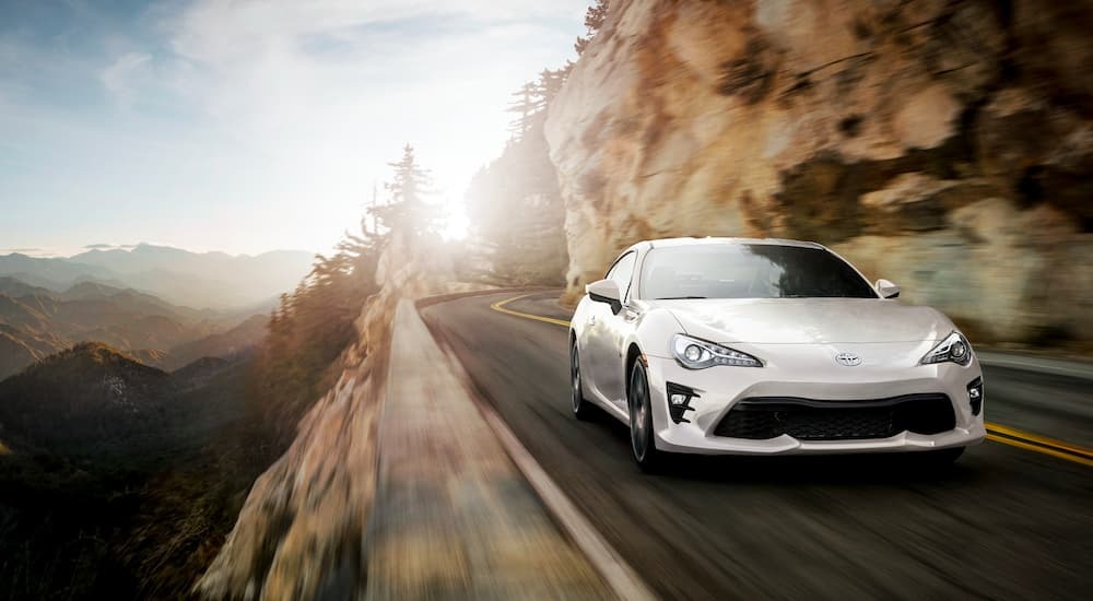 A white 2020 Toyota GT86 is shown from the front on a mountain road.