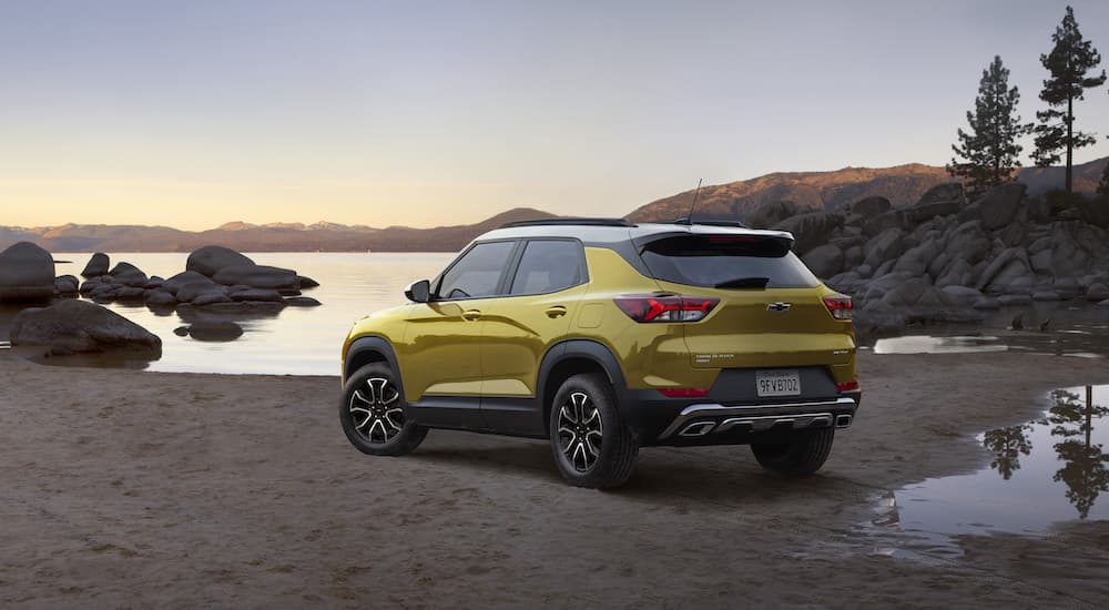 A yellow 2023 Chevy Trailblazer is shown from the rear at an angle on a lakeshore.