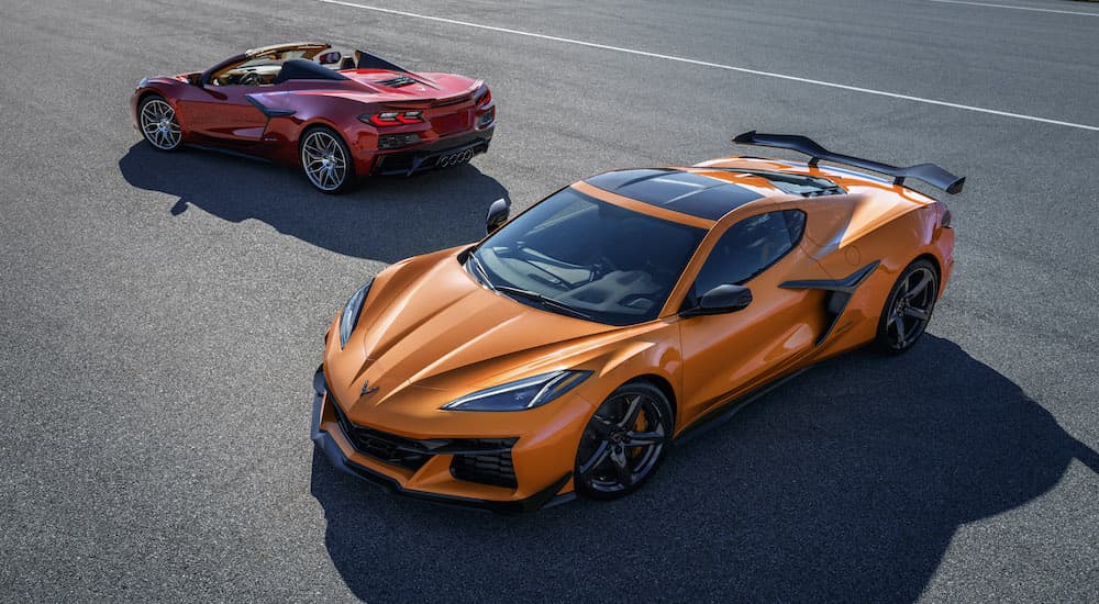 An orange and a red 2023 Chevy Corvette Z06 are shown on pavement after leaving one of the areas most popular Chevy dealers.