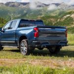 A blue 2022 Chevy Silverado High Country is shown from the rear while parked in an open field.