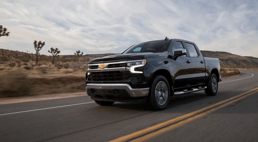 A black 2022 Chevy Silverado LT is shown driving after leaving a Chevy dealer.