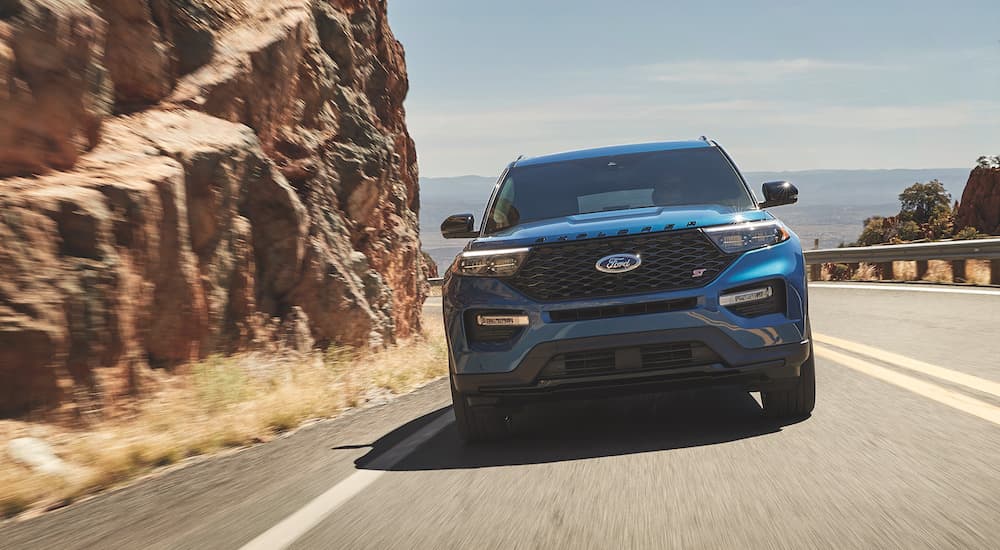 A blue 2022 Ford Explorer ST-Line is shown driving on a coastal road.