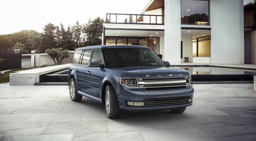 A blue 2019 Ford Flex is shown in the driveway of a modern house.