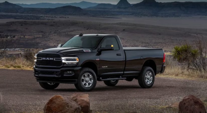 A black 2020 Ram 2500 Big Horn Sport is shown from the side after leaving a used lifted truck dealer.