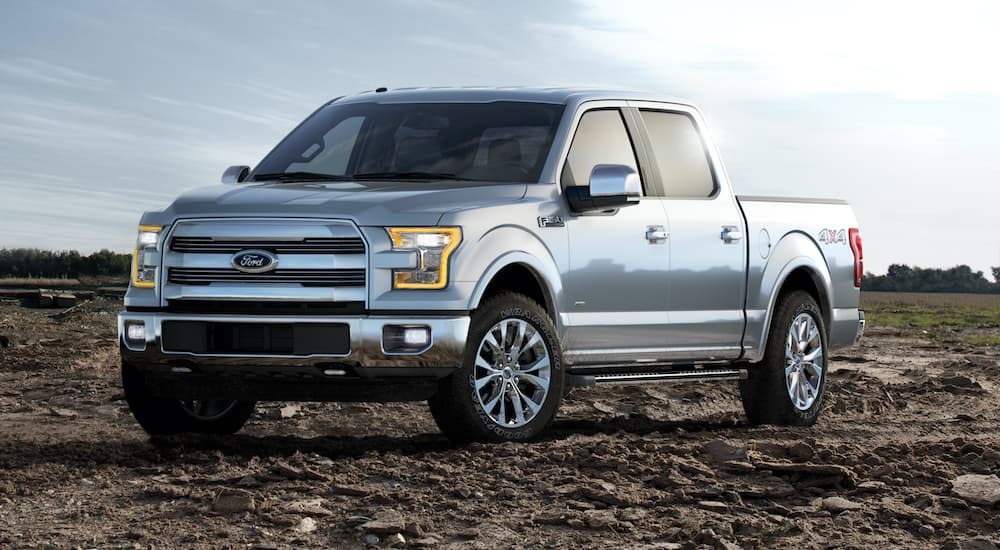 A silver 2015 Ford F-150 is shown from the front at an angle while parked off-road.