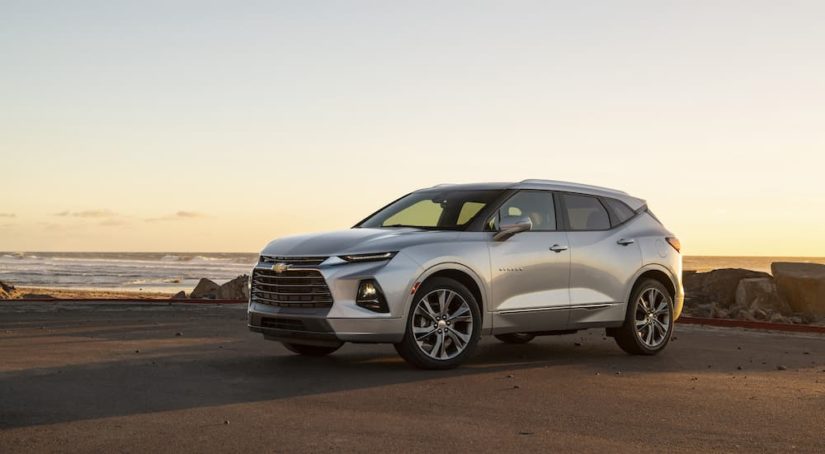 A silver 2023 Chevy Blazer Premier is shown from the side while parked on the beach.
