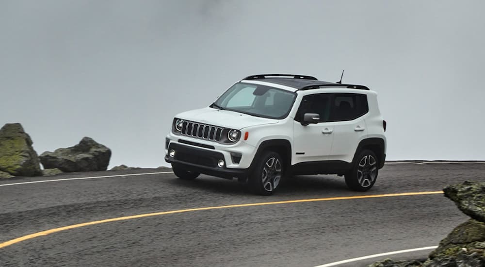 A white 2022 Jeep Renegade is shown from the front at an angle while rounding a bend.