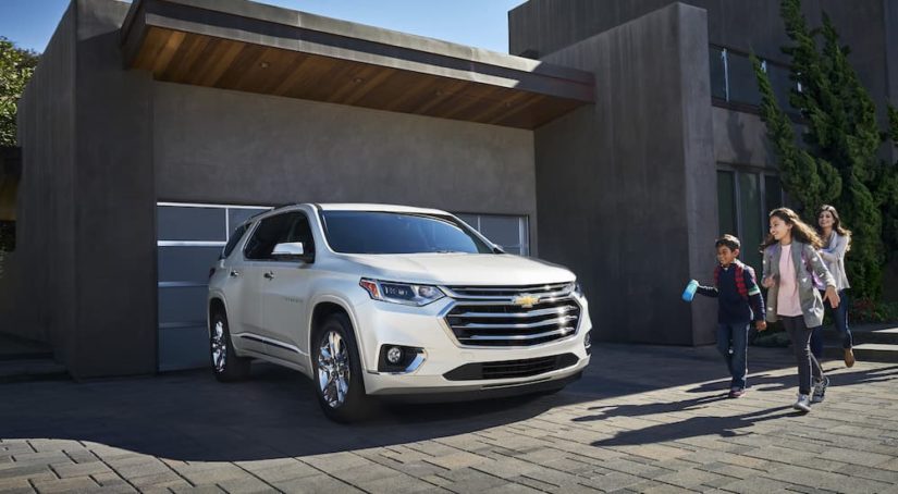 A white 2022 Chevy Traverse is shown from the front at an angle while parked in a driveway after leaving a Chevy dealership.