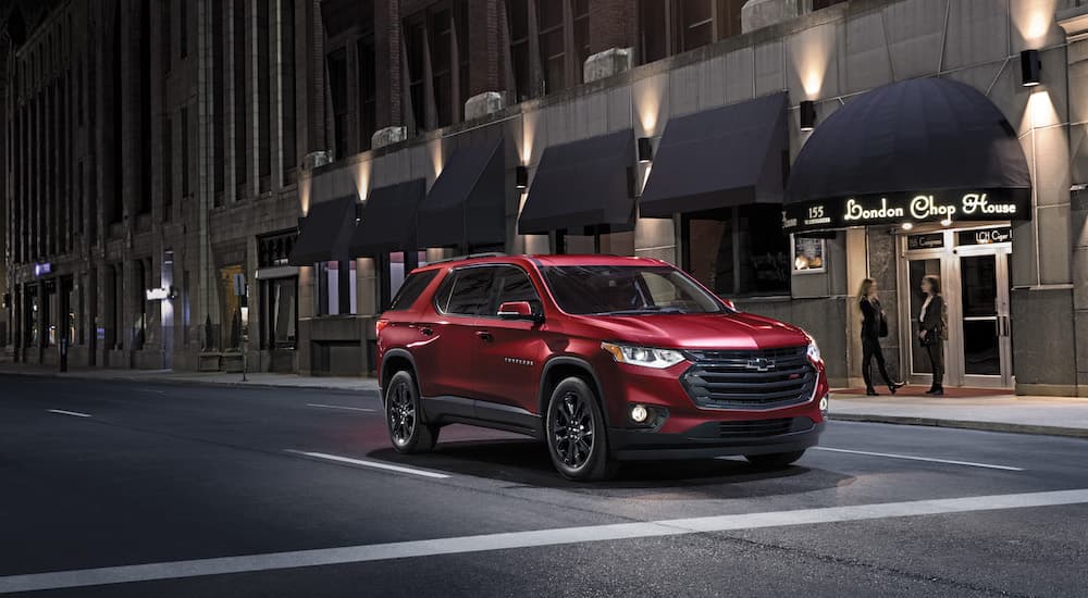 A red 2022 Chevy Traverse RS is shown from the front at an angle in a city at night.