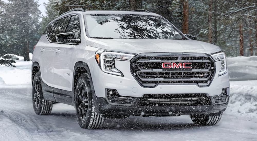 A white 2022 GMC Terrain is shwon from the front at an angle in the snow.