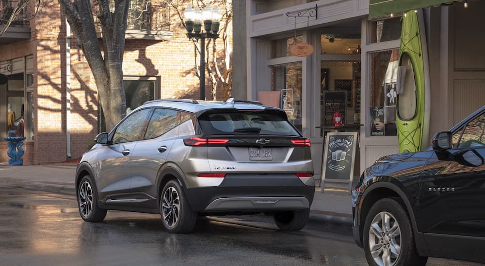 A silver 2023 Chevy Bolt EUV is shown from the rear at an angle while parked on a city street.