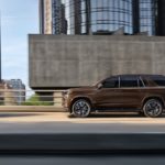 A brown 2023 Chevy Tahoe is shown from the side on the highway.