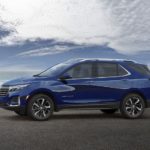 A blue 2022 Chevy Equinox is shown from the side near a body of water.