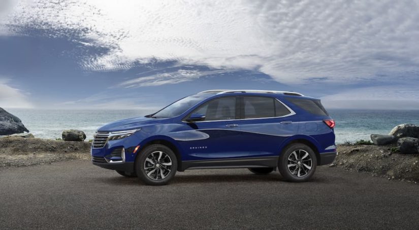 A blue 2022 Chevy Equinox is shown from the side near a body of water.