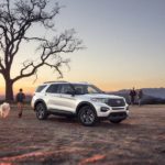 A white 2022 Ford Explorer XLT is shown parked in an open dirt area.
