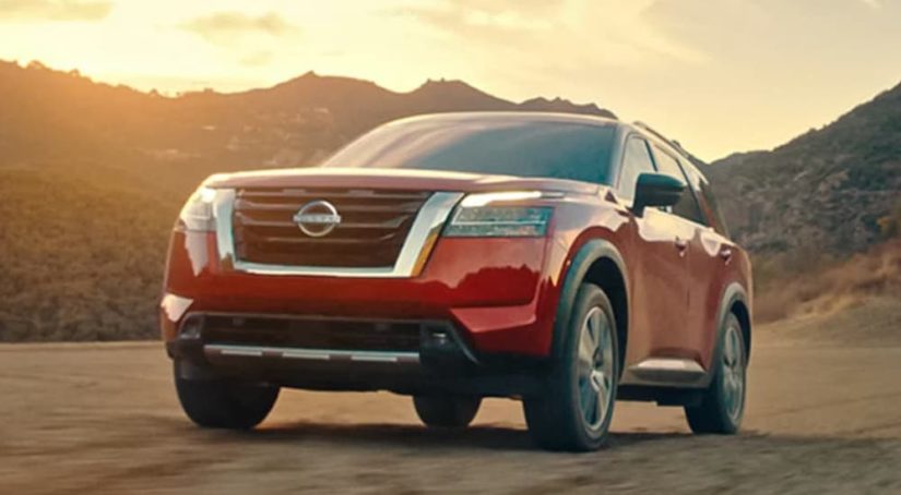 A red 2022 Nissan Pathfinder is shown from the front at an angle after the owner searched for 'online car sales'.