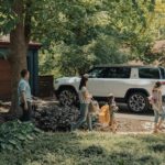 A white 2022 Rivian R1S is shown parked in a driveway.