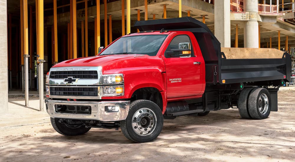 A red 2022 Chevy Silverado 6500HD is shown parked near a construction site.