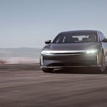 A grey 2022 Lucid Air GT is shown from the front at an angle while rounding a corner at speed.