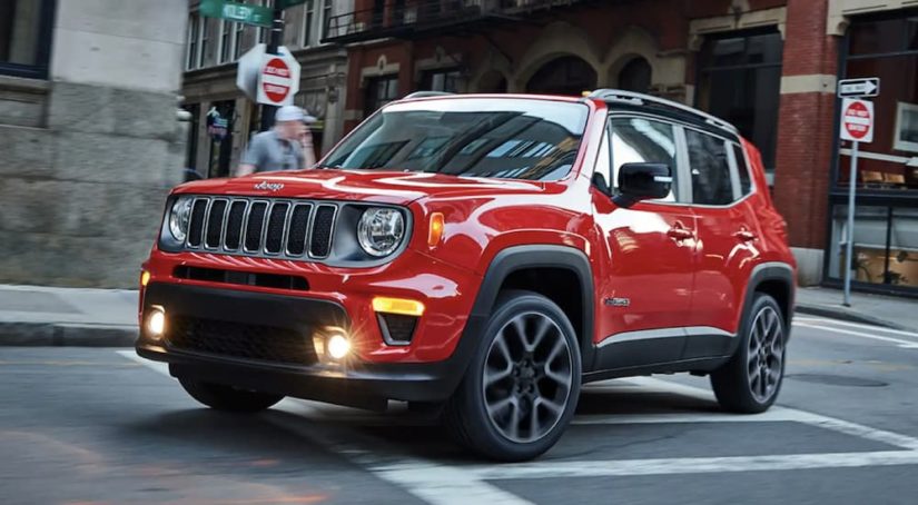 A red 2022 Jeep Renegade 4x4 is shown driving through a city.
