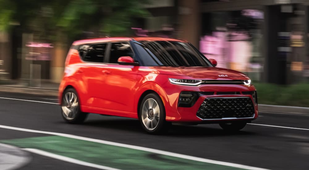 A red 2020 Kia Soul is shown on a city street.